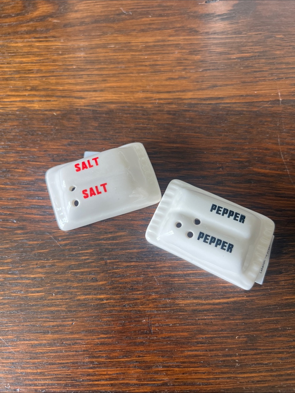 White Ceramic Salt & Pepper Shakers with Red and Black Lettering